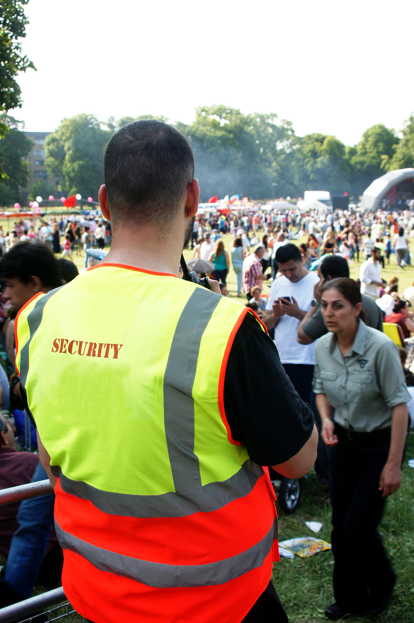 Security of a Park Festival London, England - July 7,2013: Security guard watches the crowd during one of the summer outdoor music festivals in London.